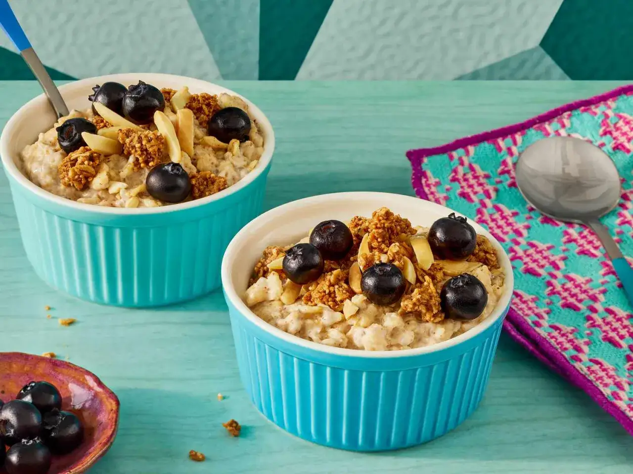 Zwei Schalen Haferflocken mit Blaubeeren und Mandeln. Ein gesunder Start in den Tag, der den hohen Haferflocken Proteingehalt nutzt.