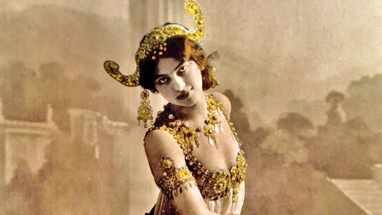 Mata Hari, la ex&oacute;tica bailarina, luce un elaborado tocado y joyas doradas, cautivando con su mirada misteriosa.