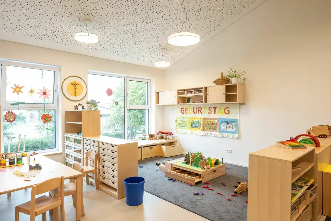 Ein heller, einladender Raum mit kindgerechten Möbeln und Spielzeug. Die Reggio Raumgestaltung Kita fördert Kreativität und Entdeckung.