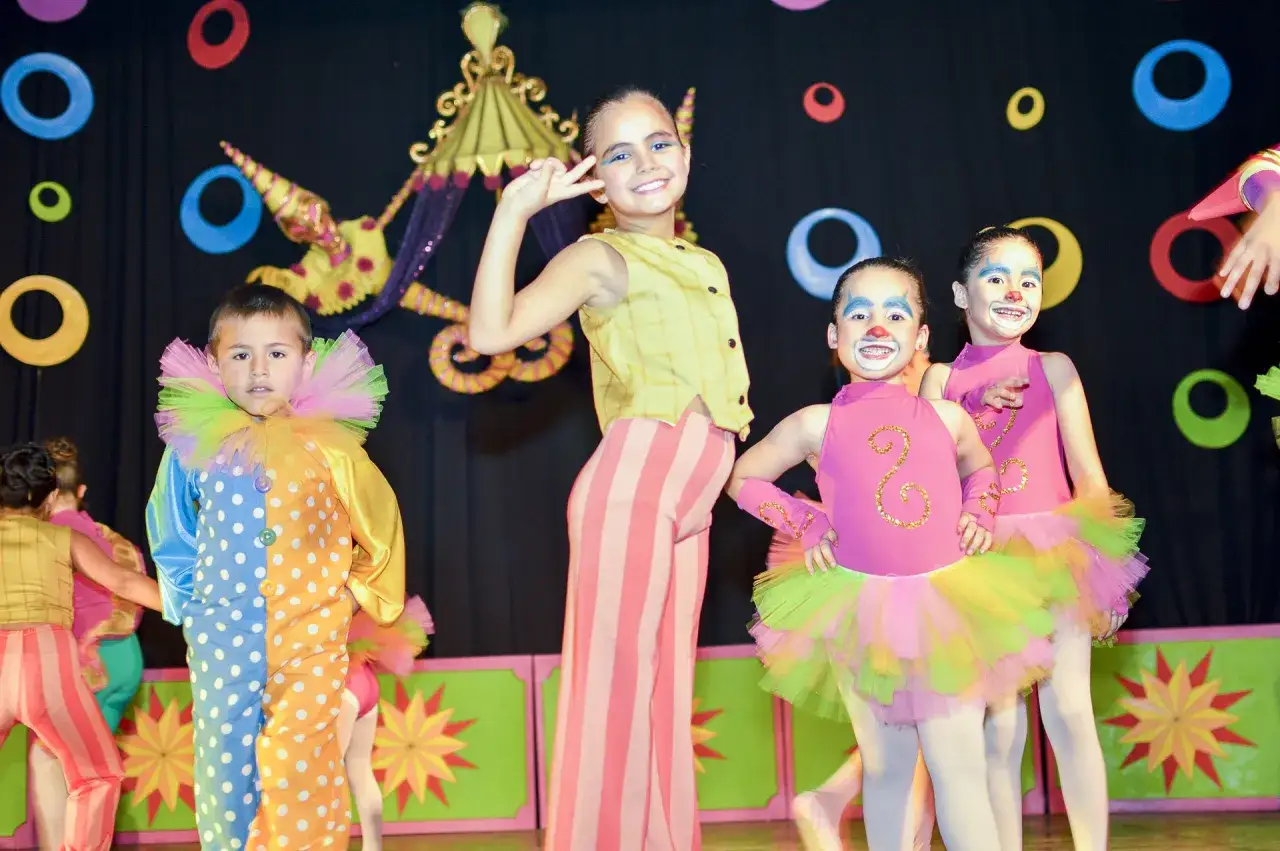 Ni&ntilde;os disfrutan en un divertido teatro de circo, con disfraces coloridos y maquillaje de payaso.