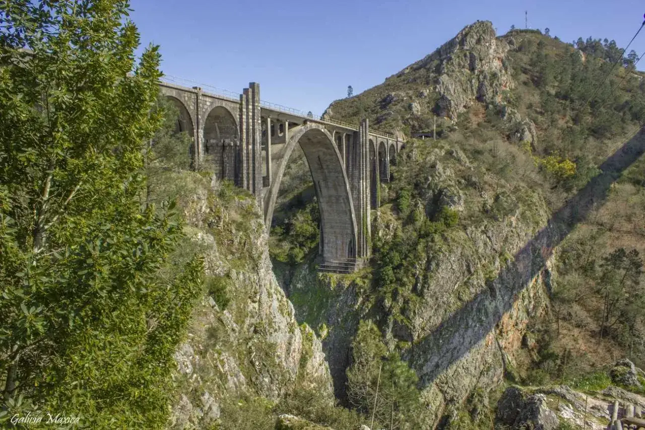 El mirador de Gundian ofrece vistas espectaculares de un imponente viaducto de piedra sobre un profundo cañón, rodeado de vegetación y montañas escarpadas.