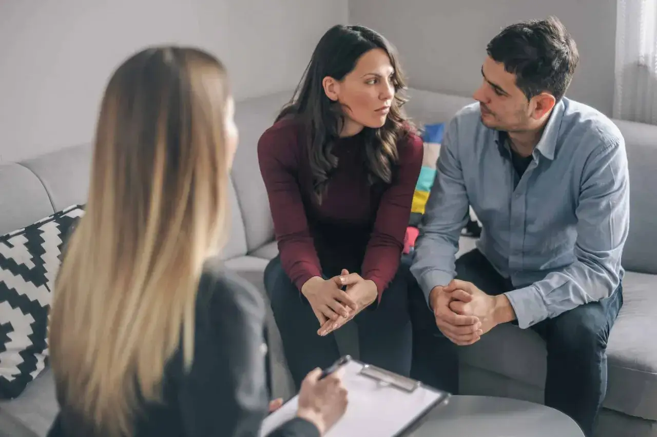 Un couple discute avec un thérapeute, cherchant le meilleur psychologue pour couple afin de renforcer leur relation.