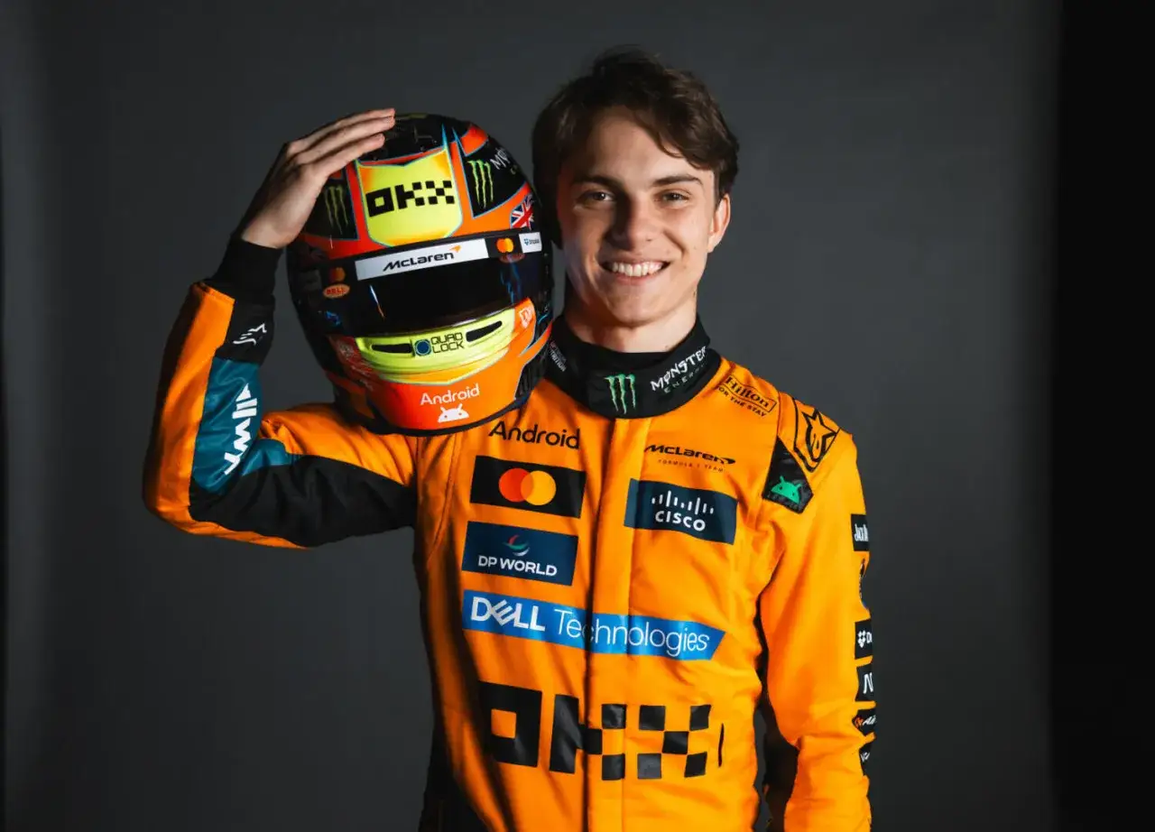 Oscar Piastri, piloto de McLaren, sonr&iacute;e con su casco naranja y negro.