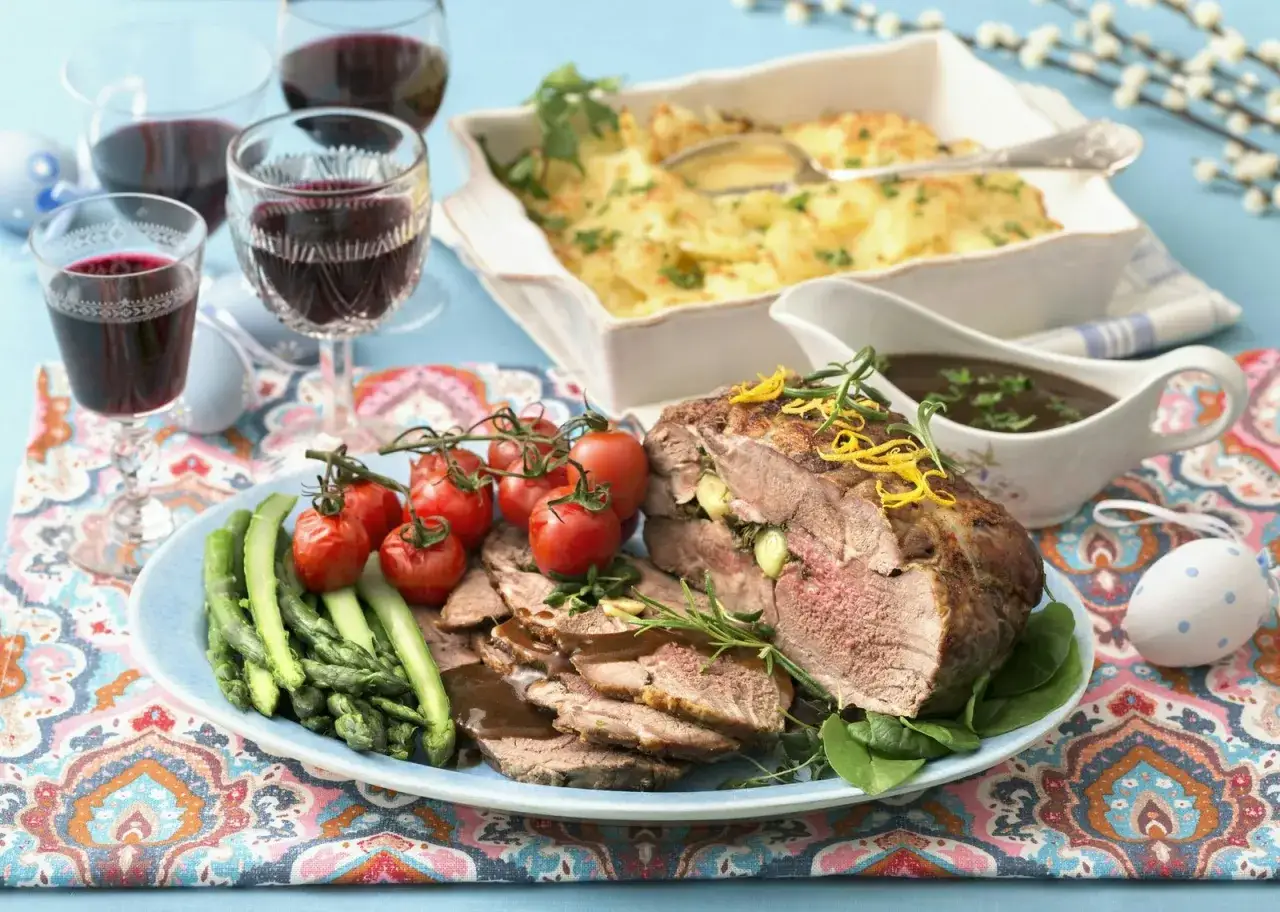 En h&auml;rlig p&aring;skbord mat med rostbiff, sparris, tomater och potatisgrat&auml;ng. R&ouml;dvin i glasen och p&aring;skpynt full&auml;ndar dukningen.