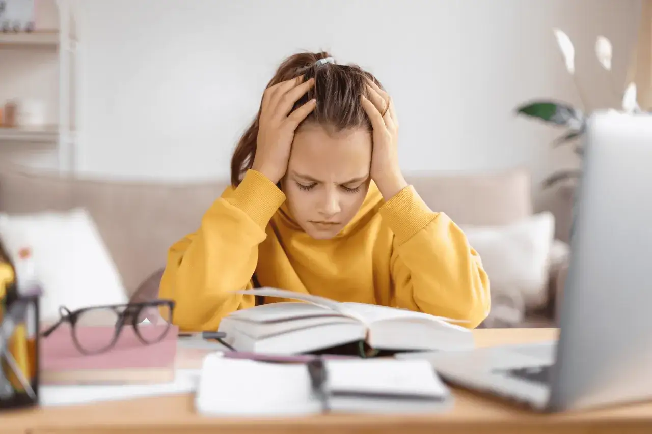 dziecko mające problemy z czytaniem i pisaniem przy biurku