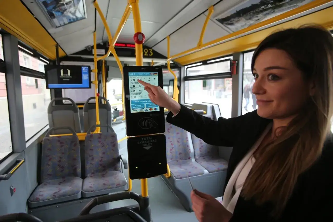 Kobieta wybiera ceny biletów MPK Wrocław na ekranie dotykowym w autobusie.