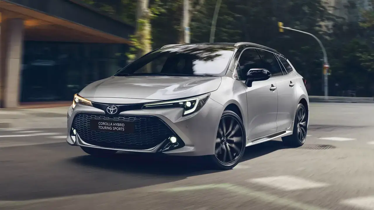 Srebrna Toyota Corolla 2.0 Hybrid Touring Sports w ruchu miejskim.
