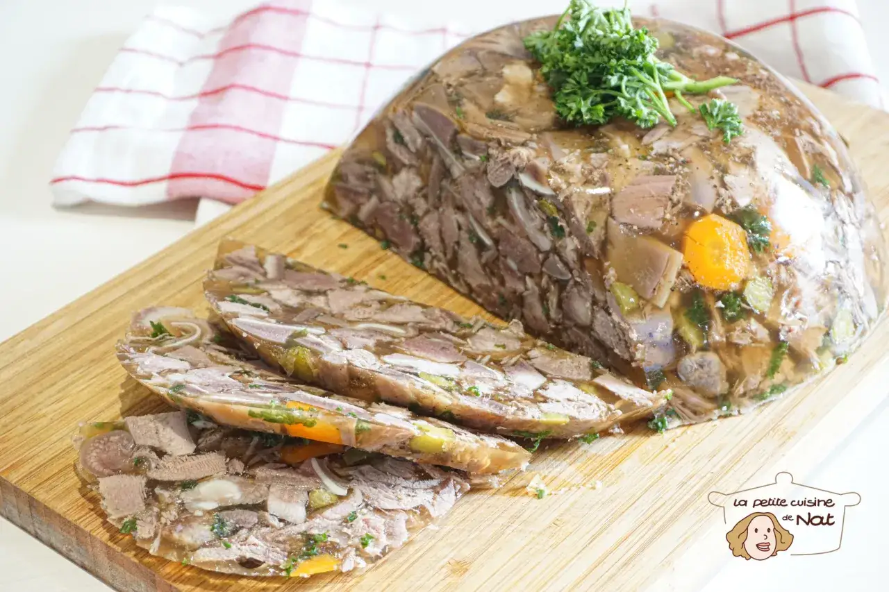 Tranché sur une planche en bois, un fromage de tête appétissant, garni de persil frais et de carottes.