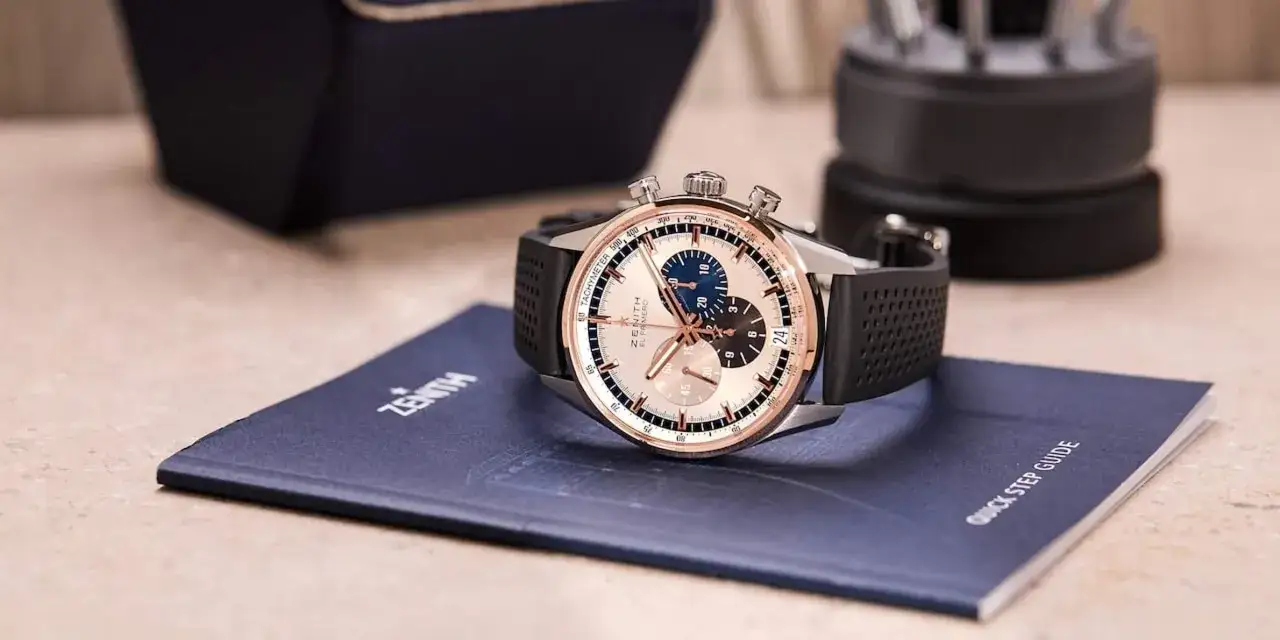 Orologio cronografo Zenith El Primero con cinturino in gomma nera, posato su un manuale 