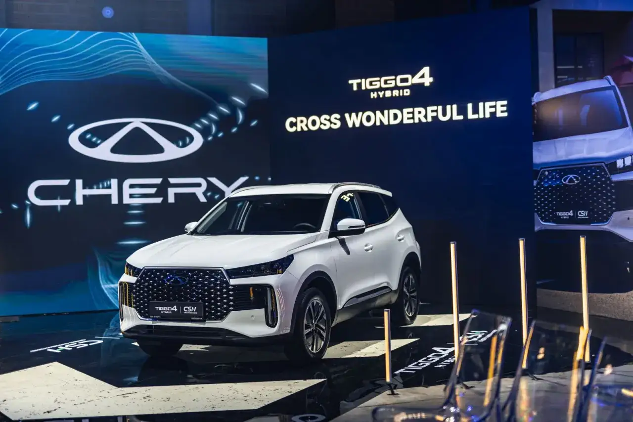 Nowy auto Chery Tiggo 4 Hybrid na scenie, z logo marki i hasłem 