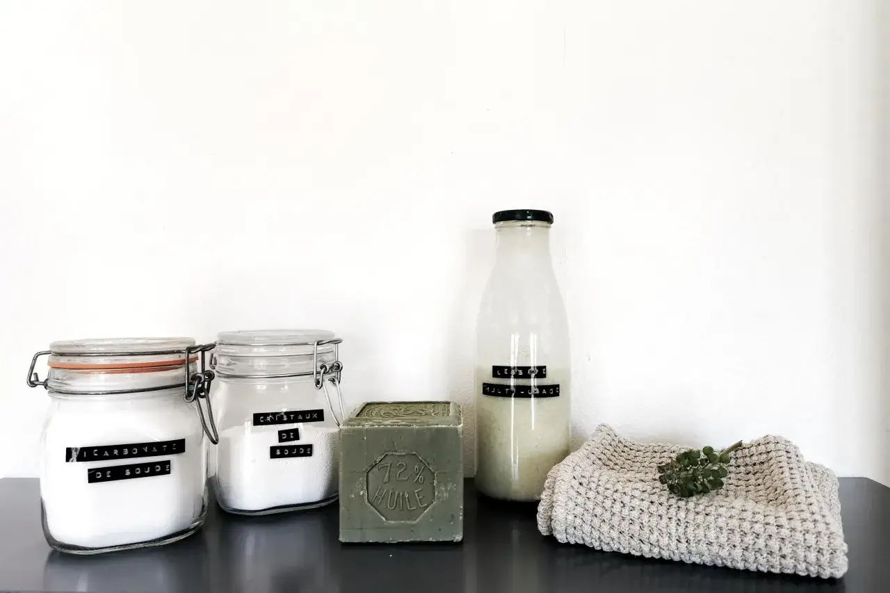 Bocaux de bicarbonate et cristaux de soude, savon de Marseille, et une bouteille étiquetée
