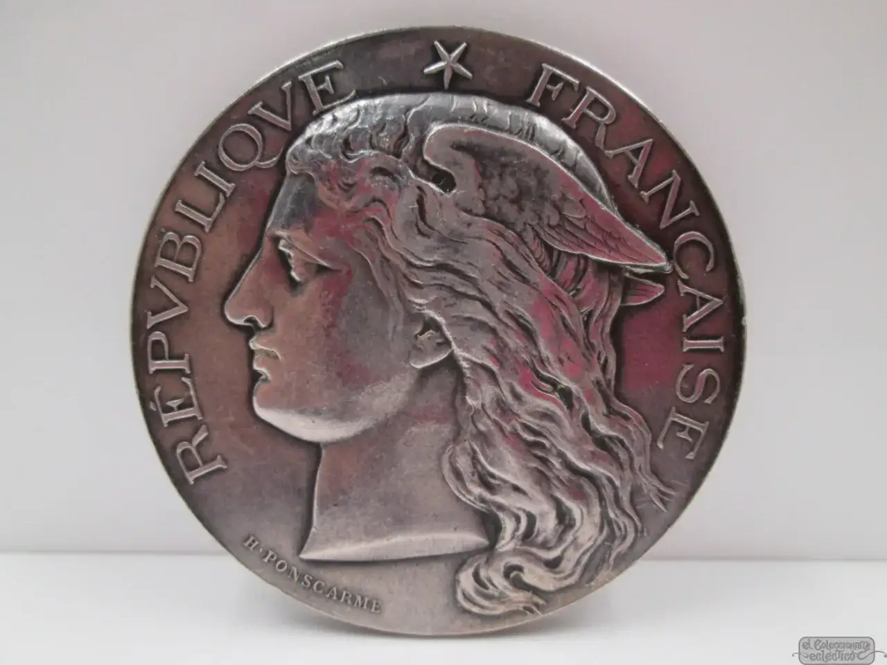 Moneda de la República Francesa con perfil de Marianne y alas. H. Poncarmé.