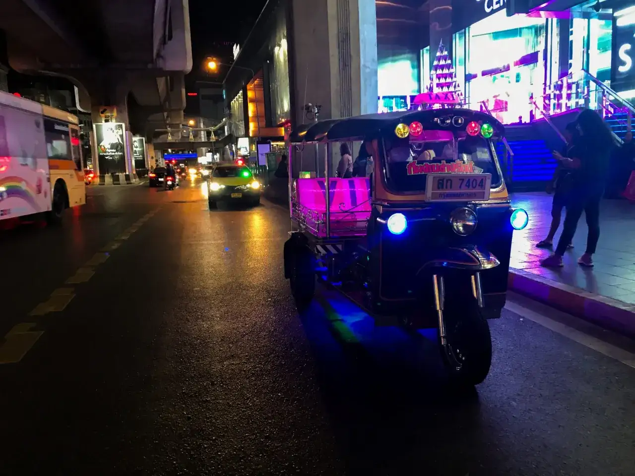 Nocny Bangkok, tuk-tuk z neonowym oświetleniem i taksówka. Czy Bangkok jest bezpieczny? Miasto tętni życiem, a transport jest łatwo dostępny.