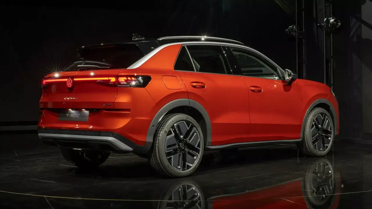 Pomarańczowy Volkswagen T-Roc z czarnym dachem, nowoczesnymi światłami LED i stylowymi felgami. Sprawdź jego atrakcyjną **volkswagen t-roc cena**!