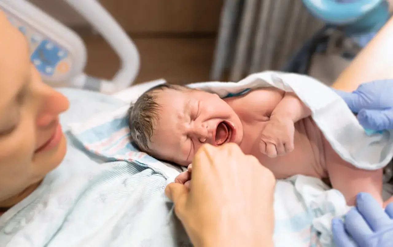Nowy człowiek na świecie! Mama patrzy z miłością na swoje maleństwo, które właśnie otrzymało swój pierwszy 