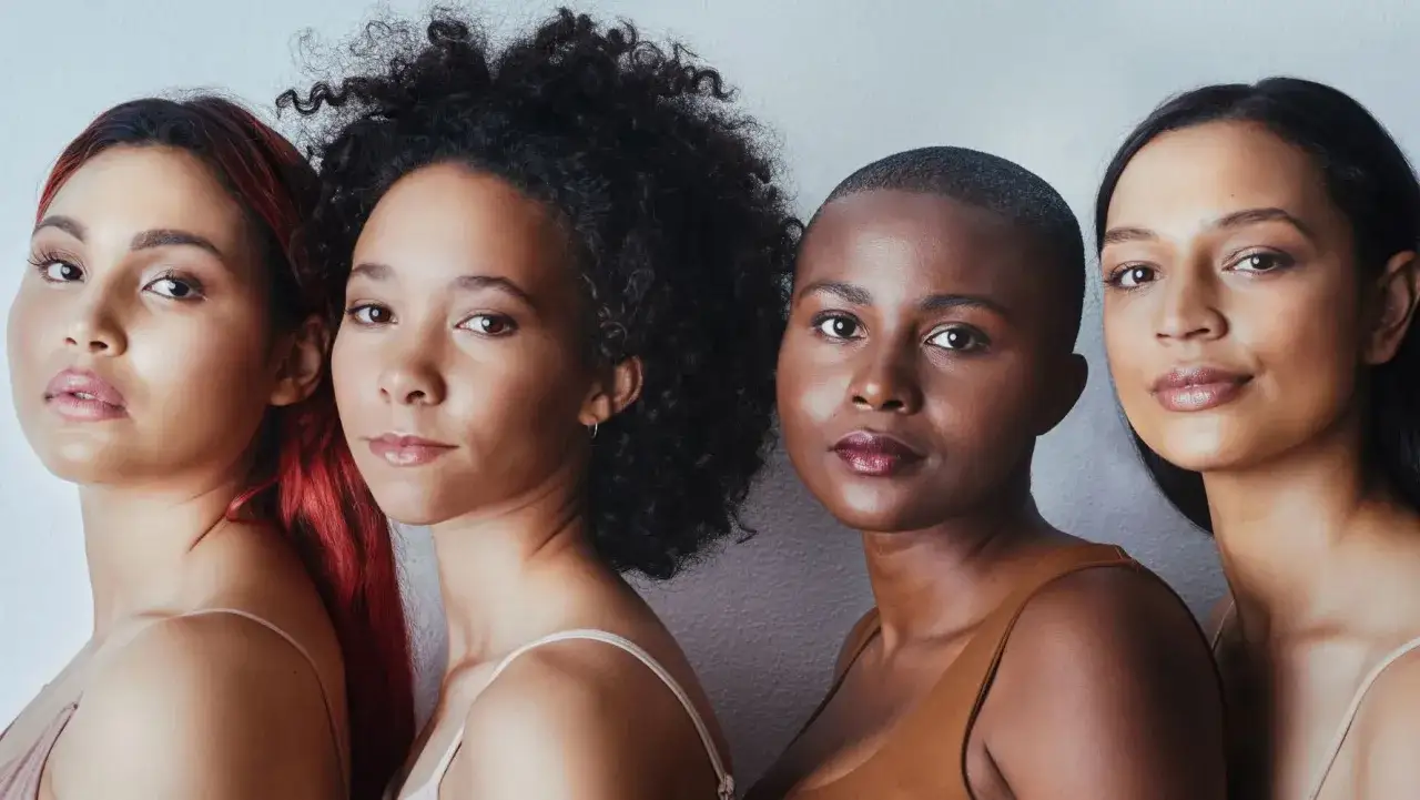 Vier Frauen mit unterschiedlichen Hautt&ouml;nen und Frisuren, die sich auf ihre Hautpflege konzentrieren.