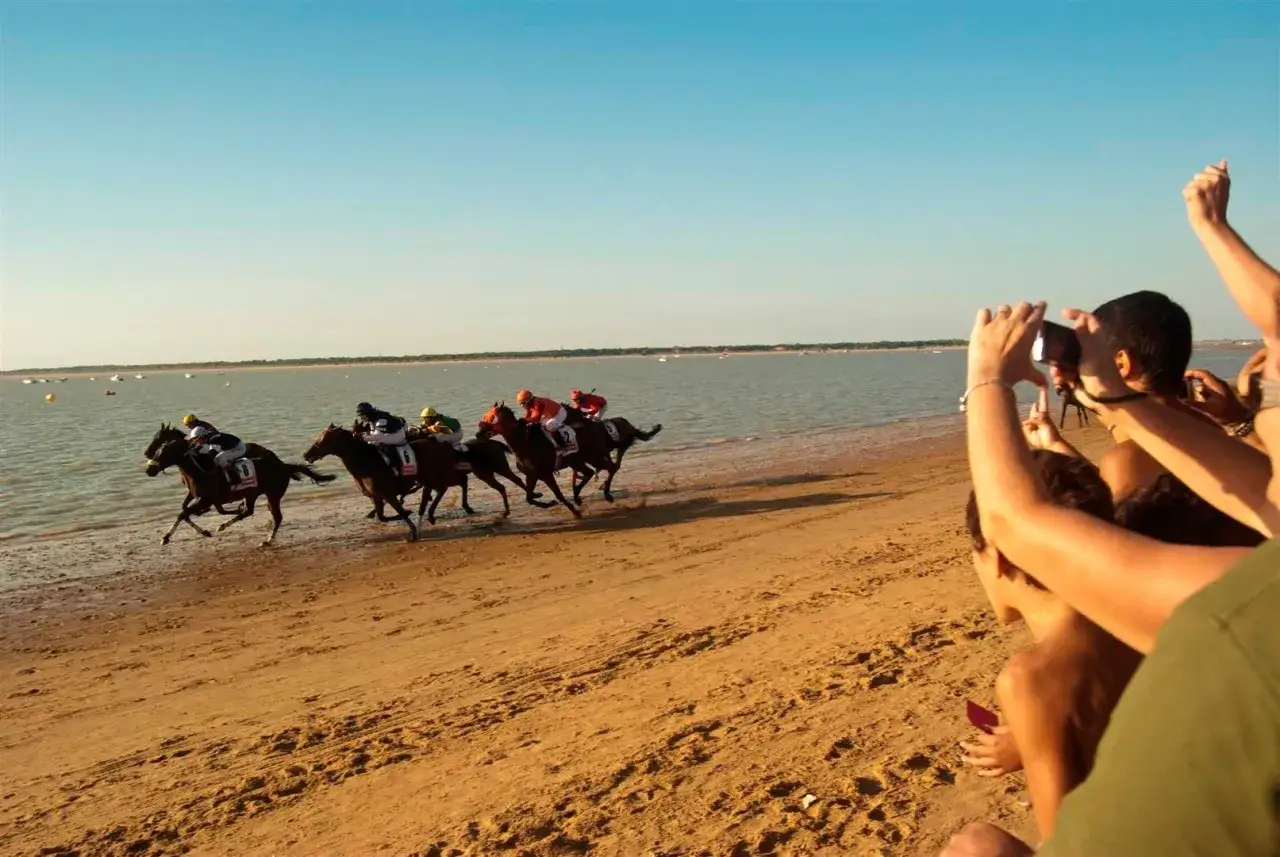 Carreras de caballos en la playa, una escena típica para saber cómo llegar a Sanlúcar de Barrameda.