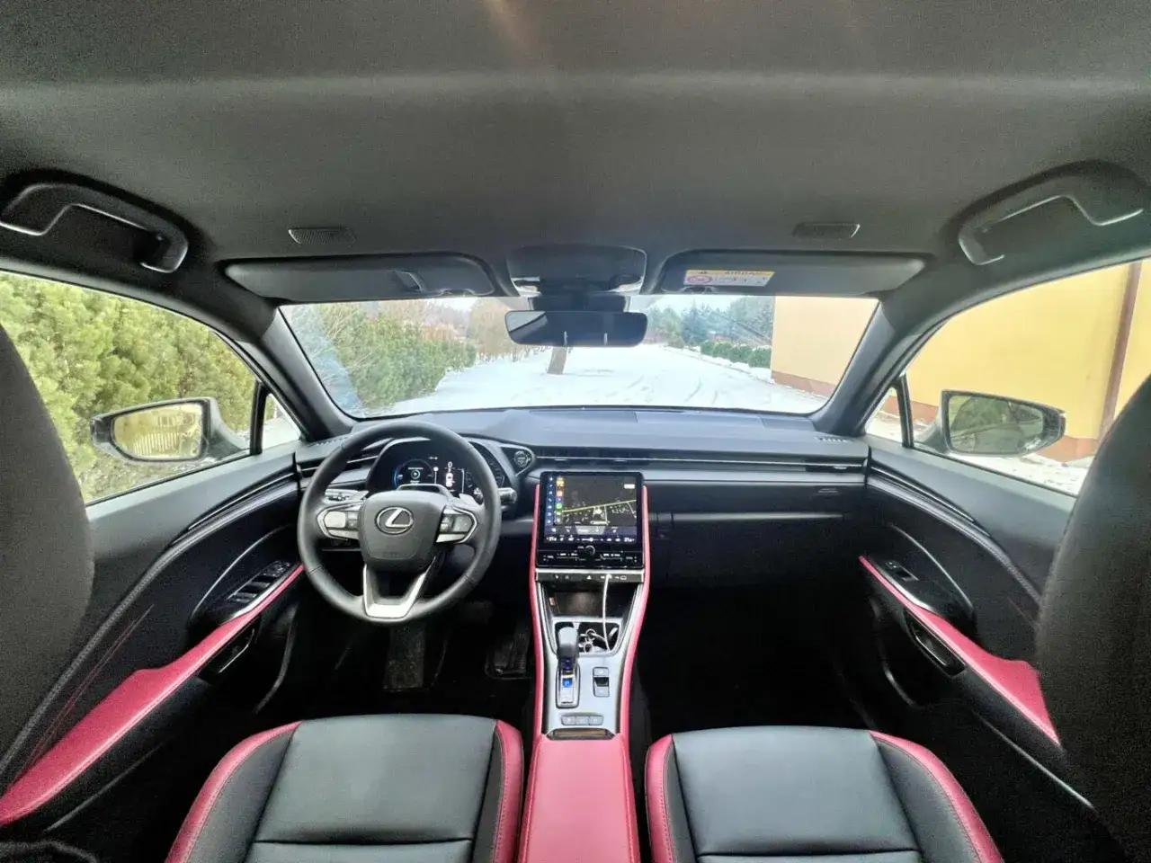 Wnętrze Lexusa LBX z czerwono-czarną tapicerką i ekranem multimedialnym. Zastanawiasz się nad lexus lbx wymiary?
