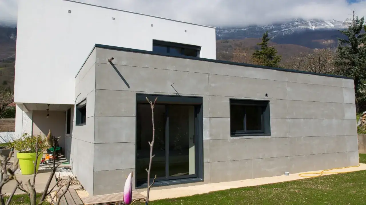 Maison moderne avec extension en béton. Le prix d'une extension maison 20m2 peut varier, mais ce style architectural offre une esthétique contemporaine.