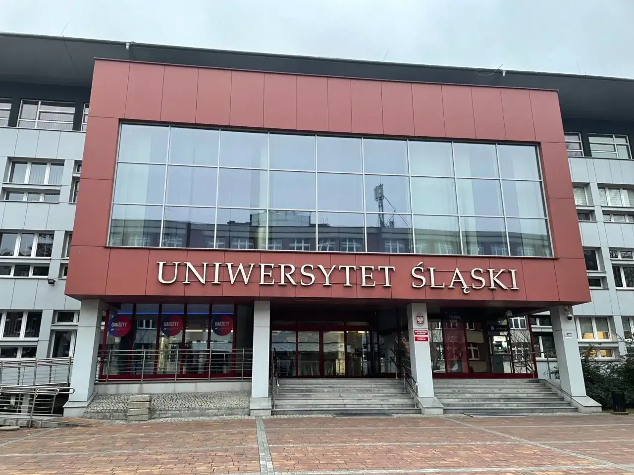 Nowoczesny budynek Uniwersytetu Śląskiego w Katowicach. Wita studentów i gości.