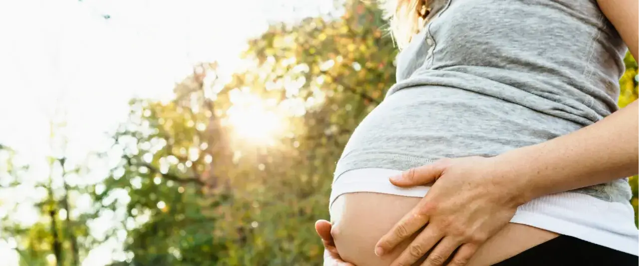 Schwanger in 40. SSW, die Sonne scheint, aber Hitzewallungen machen zu schaffen. Der Bauch ist gro&szlig; und rund.