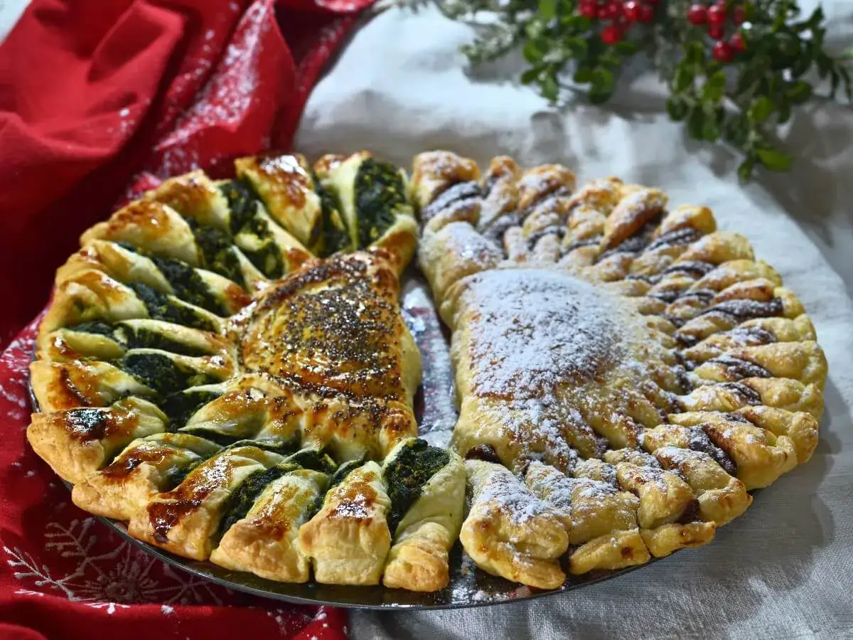 Delizioso ciasto francuskie a forma di sole, metà con spinaci e semi di papavero, metà con crema al cioccolato e zucchero a velo.