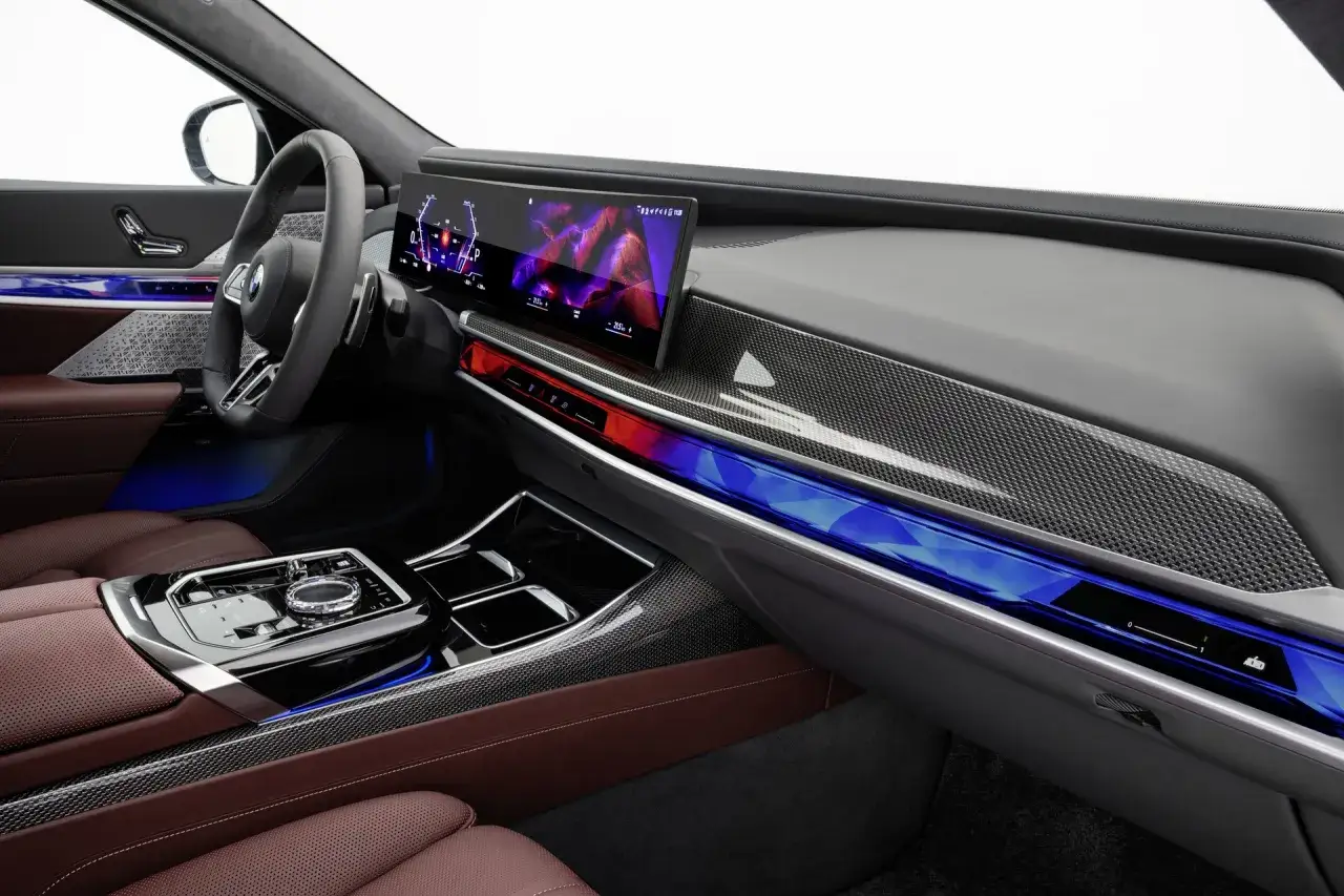 Wnętrze BMW 7 2025 z nowoczesnym ekranem, skórzaną tapicerką i nastrojowym oświetleniem.