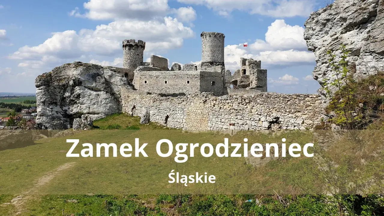 Ruiny zamku **Ogrodzieniec** na wapiennym wzgórzu, z charakterystycznymi wieżami i murami obronnymi, pod błękitnym niebem.