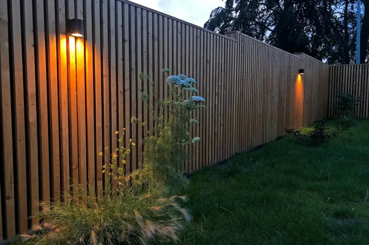 En vacker träplank med belysning skapar en mysig atmosfär i trädgården.