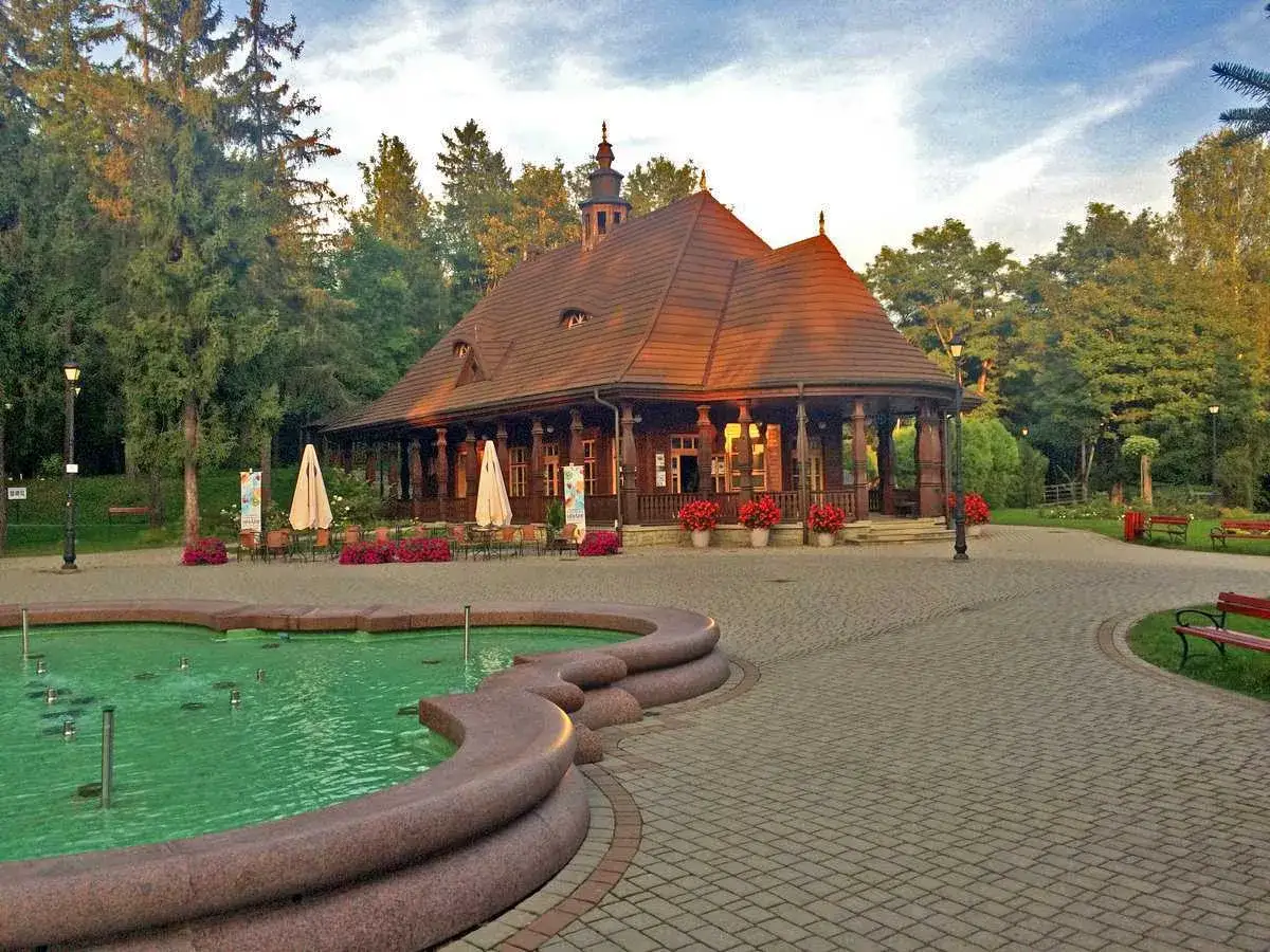 Urokliwy park w Wysowej-Zdroju z fontanną i drewnianą altaną. Wspaniałe wysowa zdr&oacute;j atrakcje dla każdego.