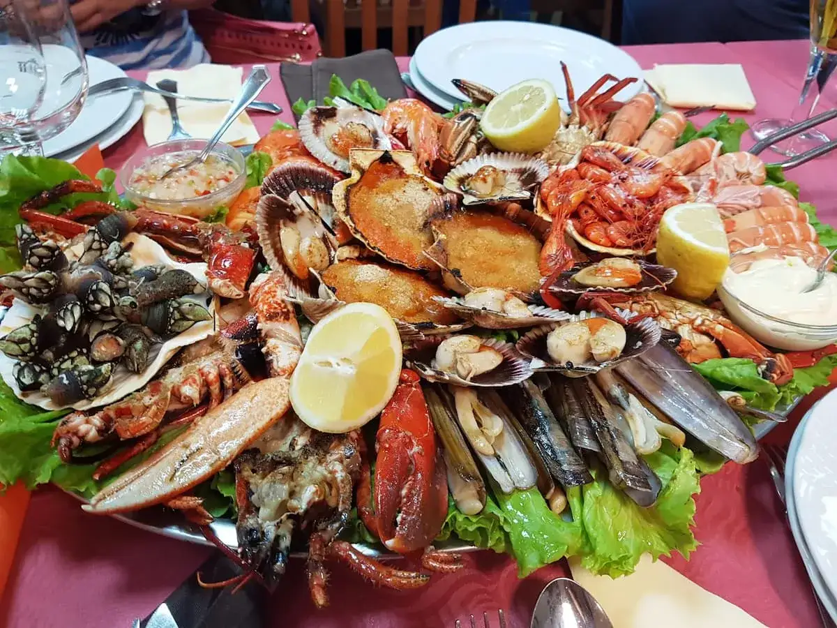 Exquisita mariscada, un festín digno de las mejores ferias del marisco en Galicia, con percebes, langostinos, vieiras y navajas.