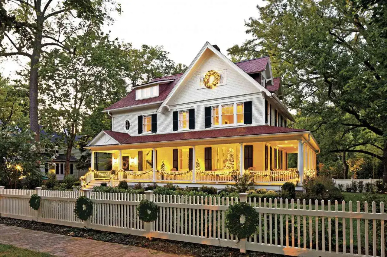 Casa adornada con guirnaldas y coronas, creando un ambiente festivo con adornos navideños caseros para exterior.