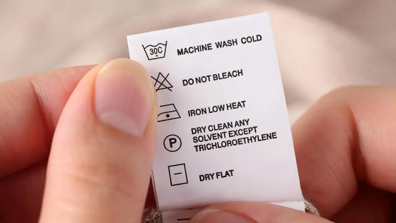 Etiqueta de cuidado textil: c&oacute;mo saber si una prenda se puede lavar en lavadora. Indica lavado en fr&iacute;o, no usar lej&iacute;a, planchar a baja temperatura y secar en plano.