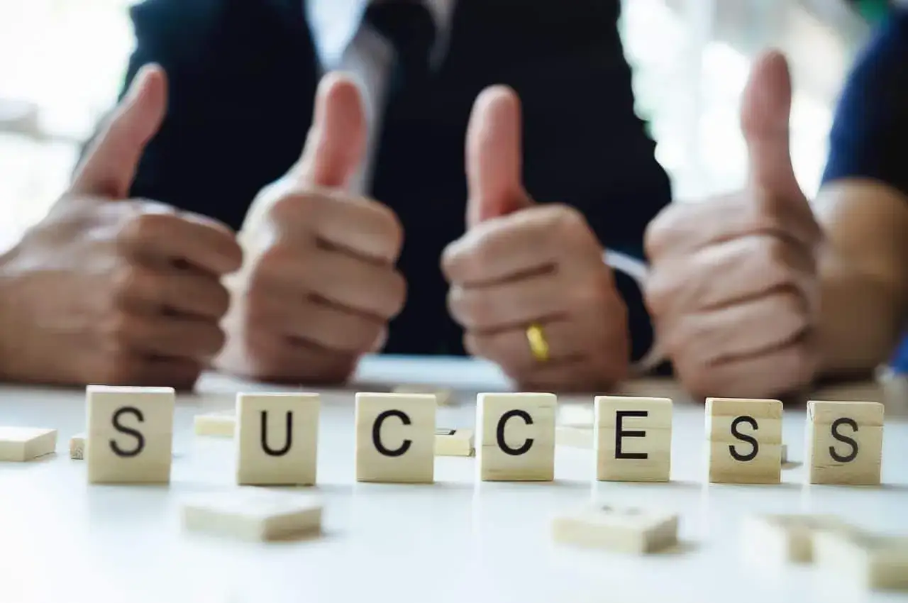 Cztery kciuki w górę i kostki z napisem SUCCESS. Sukces w biznesie, który zasługuje na success fee.