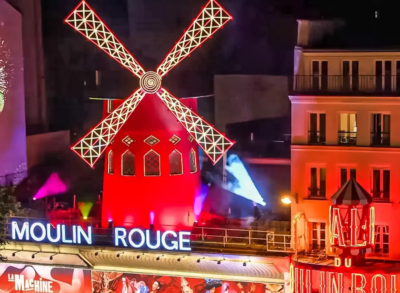 Le Moulin Rouge illuminé de nuit. Le prix d'entrée pour ce spectacle parisien emblématique est souvent demandé.