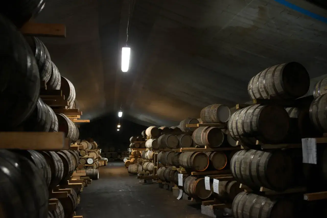 Mackmyra destilleri: tusentals ekfat lagras i en mörk, upplyst lagerhall, redo att förvandlas till svensk whisky.