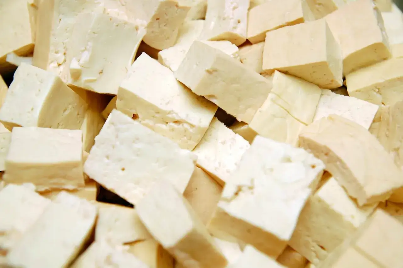 Kawałki białego tofu, które jest produktem z soi, ułożone w stos.