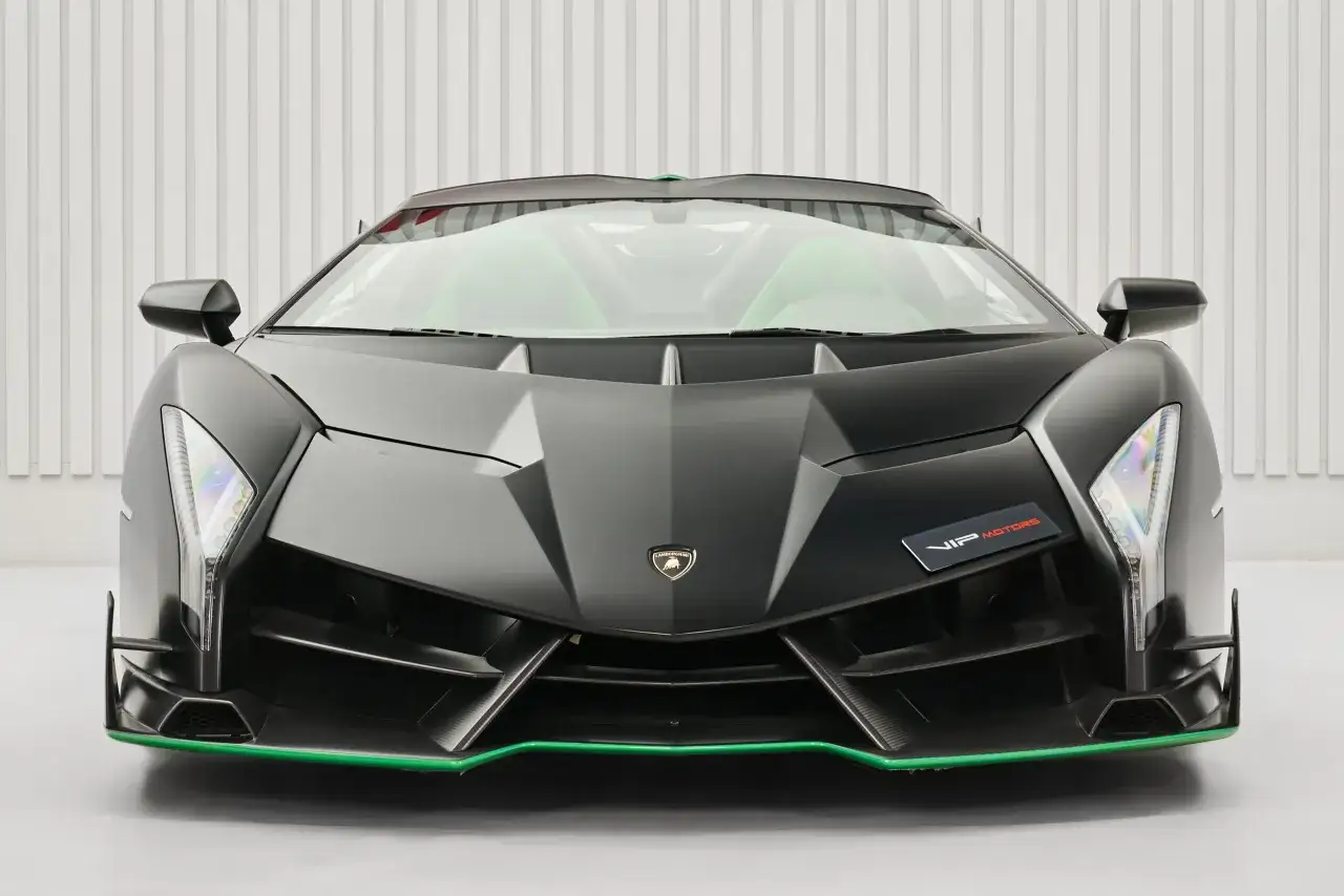 Schwarzer Lamborghini Veneno mit grünen Akzenten und auffälligen Scheinwerfern. Ein Traumauto für Enthusiasten.