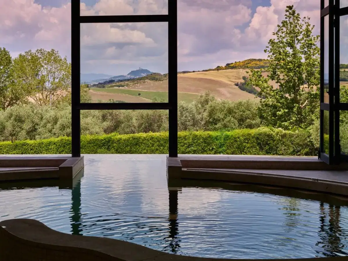 Piscina interna con vista panoramica sulle dolci colline del Val d'Orcia, Italia. Un paesaggio idilliaco per rilassarsi.