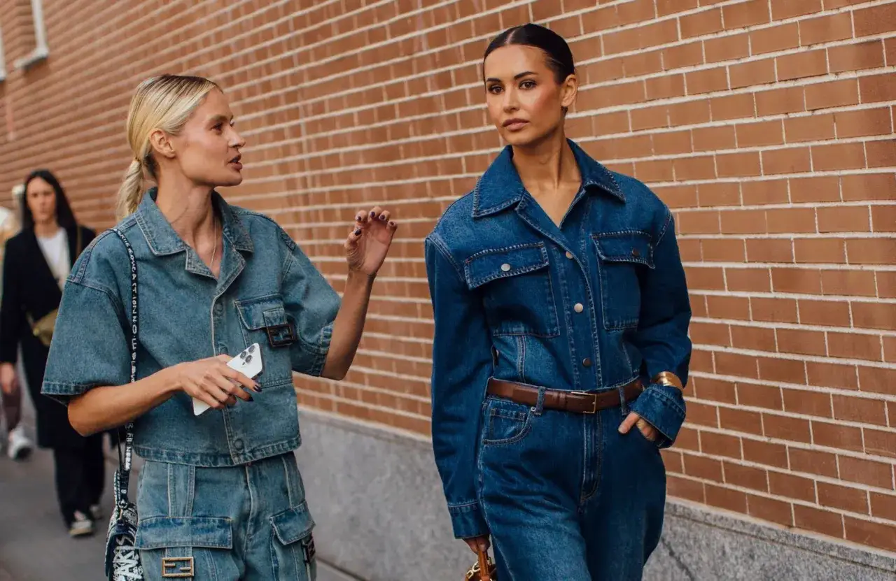 Deux femmes arborent un total look en jean, l'une avec une coupe jean courte et l'autre dans une combinaison.