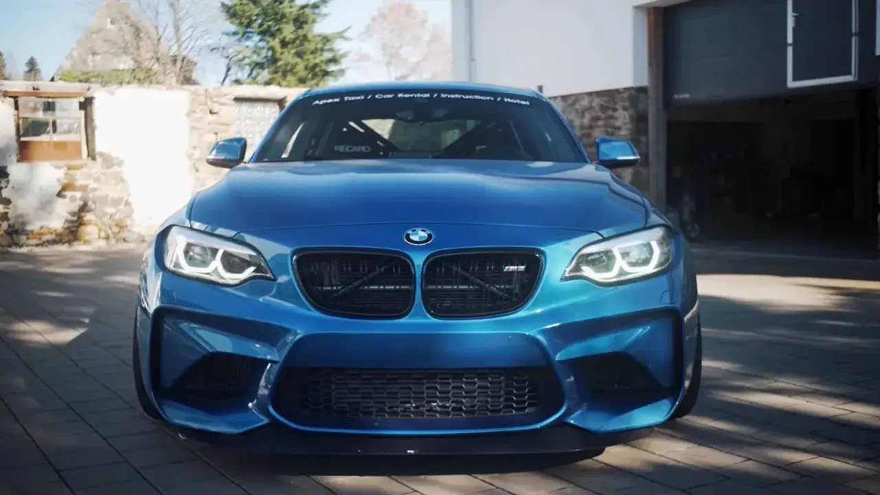 Un BMW M2 Competition azul, listo para la acci&oacute;n. Sus luces LED brillan, esperando devorar kil&oacute;metros.