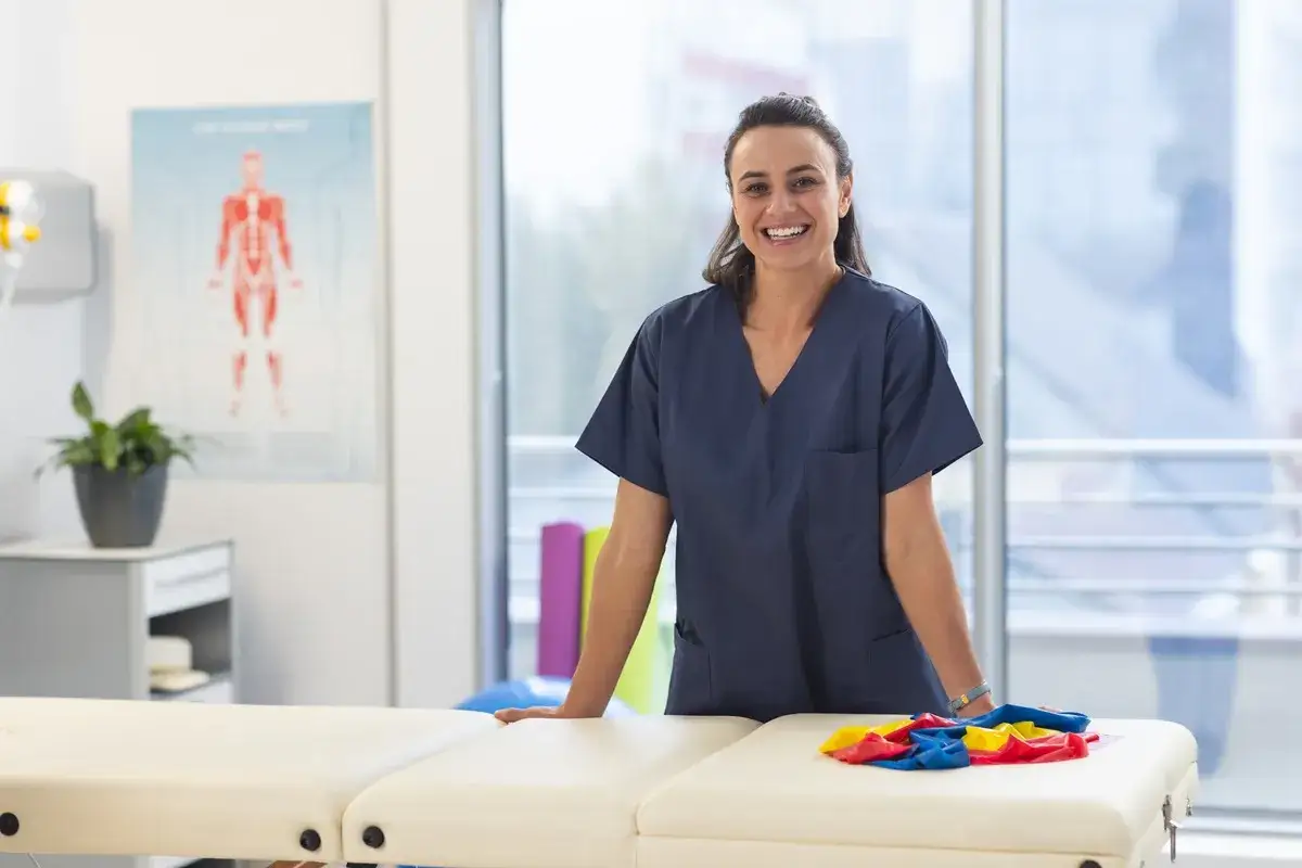 Une étudiante souriante en uniforme de kinésithérapeute, prête pour sa formation à l'école de kiné en Espagne.