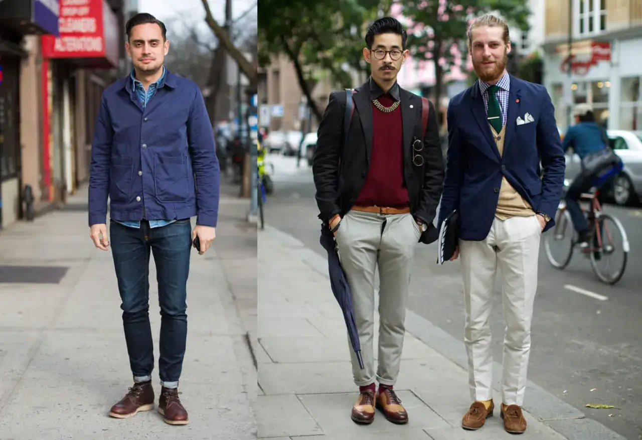 Trois hommes affichent un style casual homme impeccable. Le premier porte une veste bleue, le deuxième un pull bordeaux sous une veste noire, et le troisième un blazer bleu avec un gilet beige.