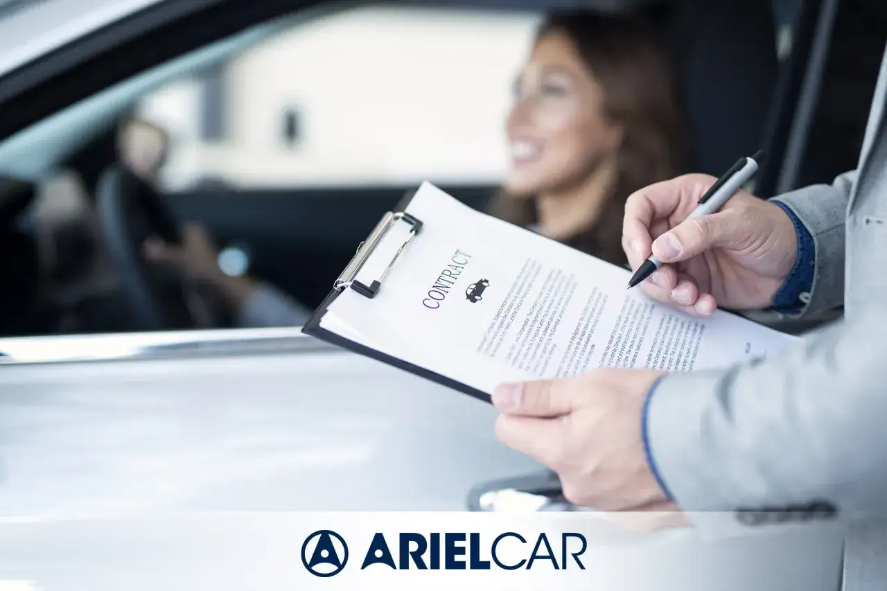 Un cliente sorridente firma un contratto per la permuta auto in concessionario.