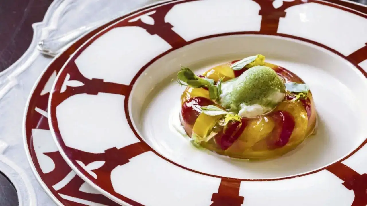 Antipasti sfiziosi per stupire freddi: gelatina di frutta con sorbetto verde e erbe aromatiche su un piatto elegante.