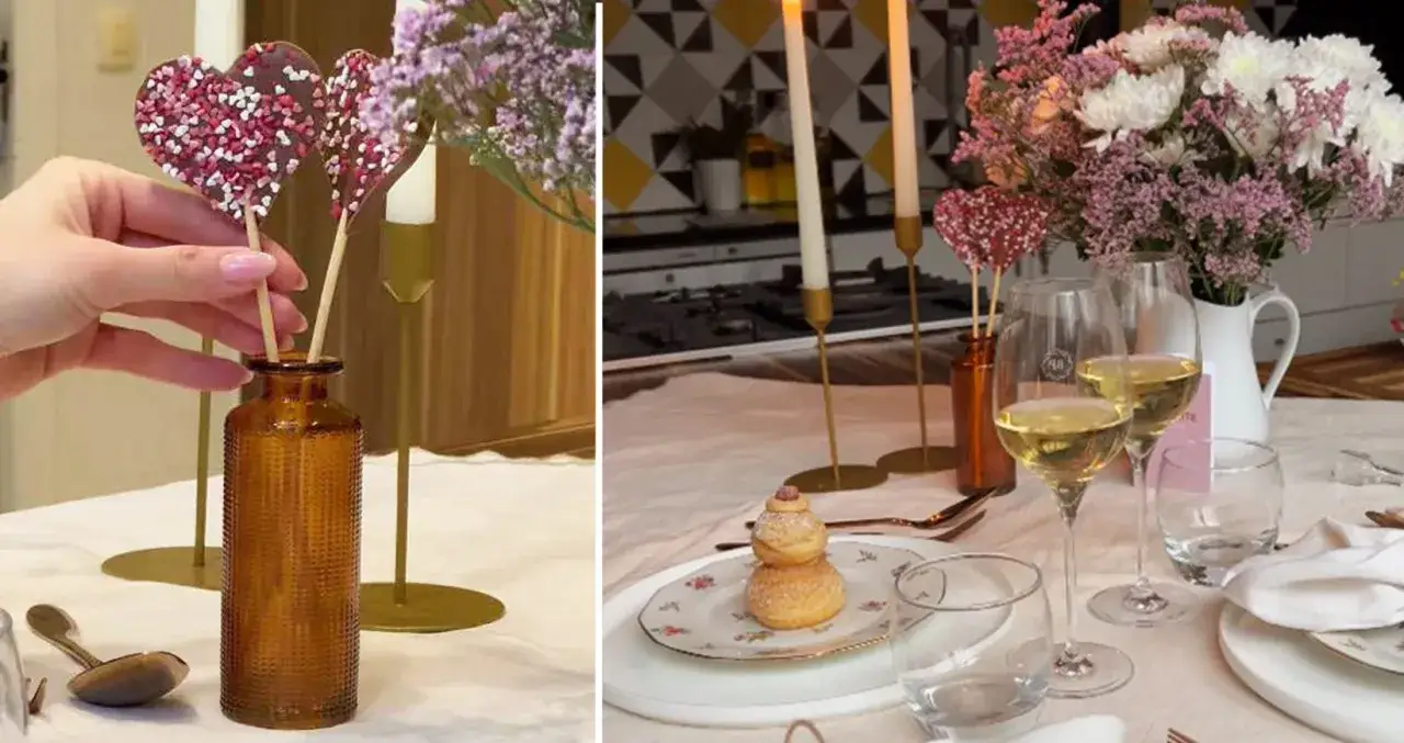 Une table dress&eacute;e avec &eacute;l&eacute;gance, des c&oelig;urs en chocolat, des fleurs et des verres de vin.