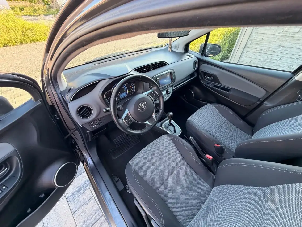Wnętrze Toyoty Yaris 2017 z szarymi siedzeniami i nowoczesnym panelem.