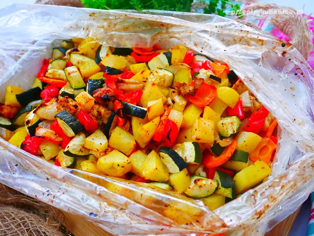 Pyszny kurczak w rękawie z ziemniakami, cukinią i papryką. Aromatyczne warzywa i soczyste mięso, idealne na szybki obiad.