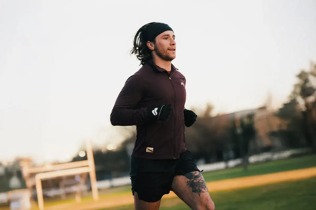 Mężczyzna w sportowym stroju biegnie po parku. Cieszy się aktywnością, nawet jeśli to bieganie po jedzeniu.