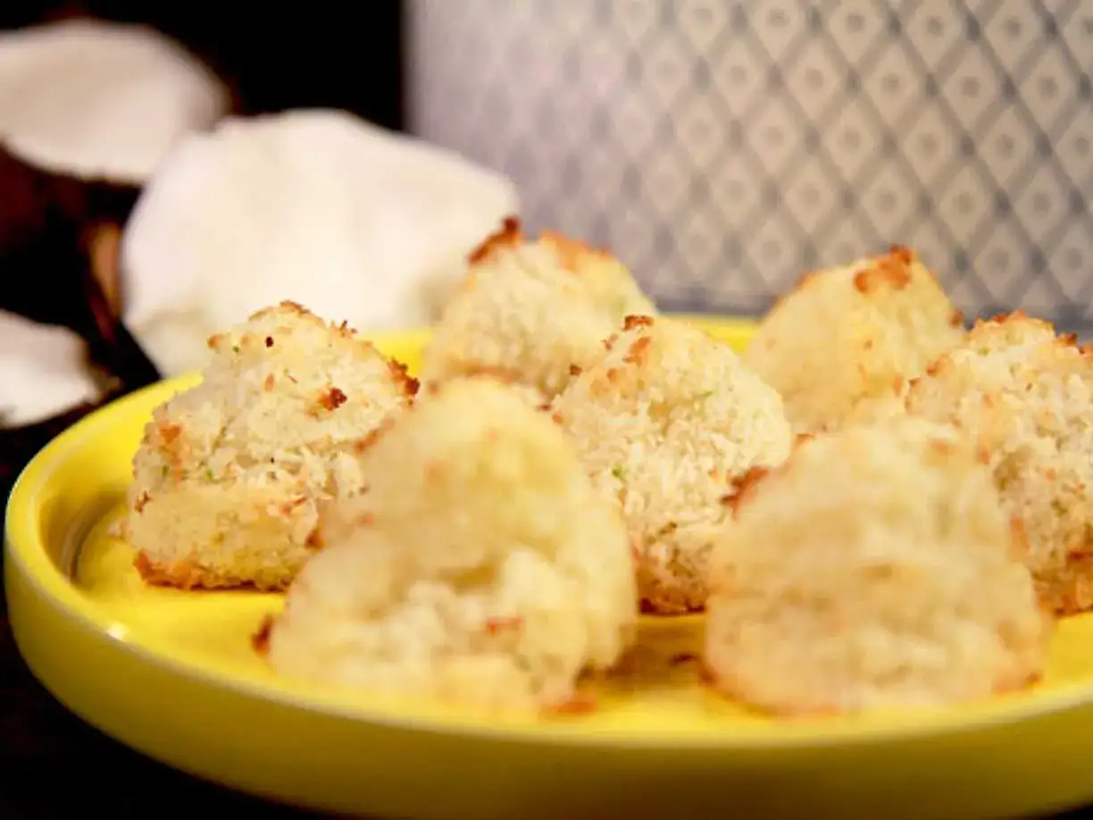 Sm&aring;, gyllene kokostoppar p&aring; en gul tallrik, redo att avnjutas. Ett enkelt kokostoppar recept f&ouml;r hembakning.